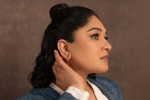 une femme portant un costume et des boucles d'oreilles regardant sur le côté