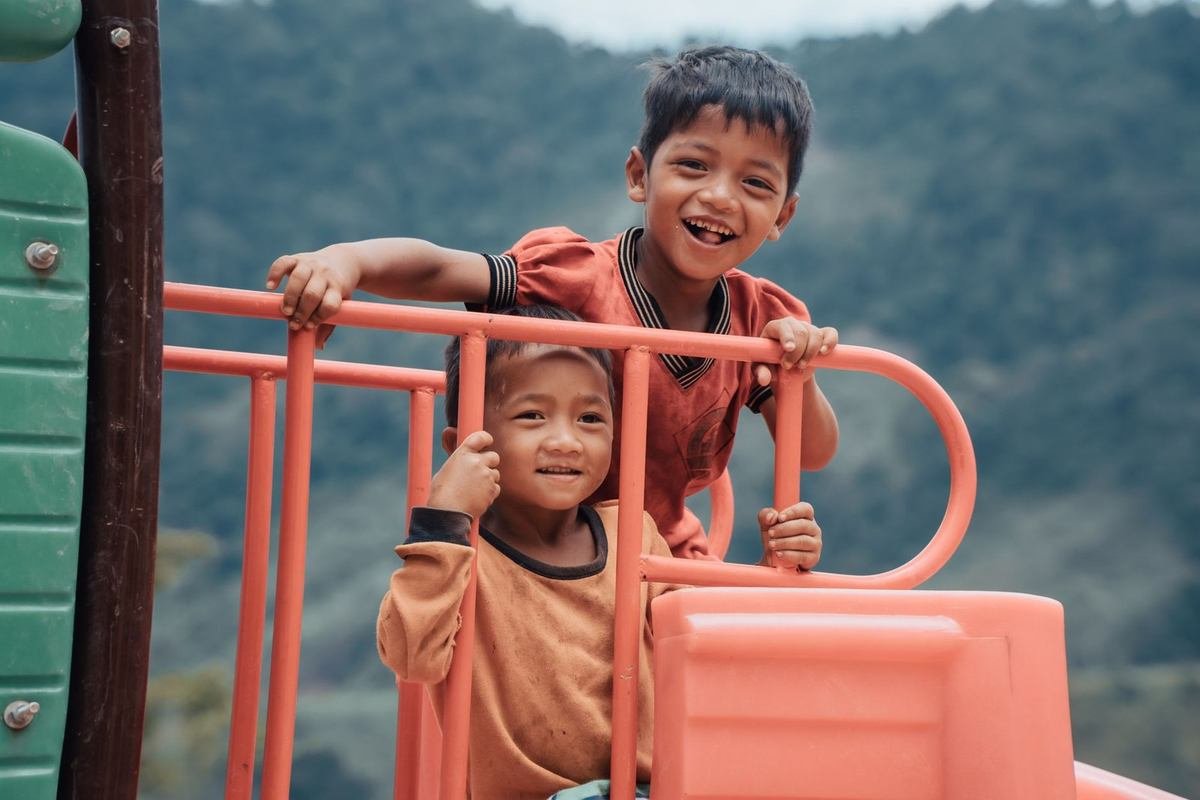 Enfants jouant sur une structure de jeu orange en extérieur Enfants jouant sur une structure de jeu orange en extérieur