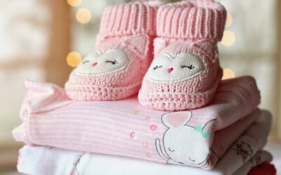 Chaussons tricotés roses posés sur couches bébé aux motifs animaux