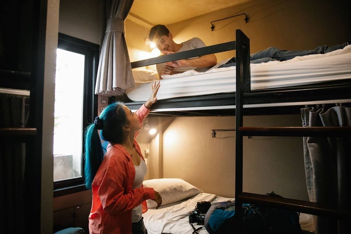 Deux personnes dans une chambre avec des lits superposés Deux personnes dans une chambre avec des lits superposés