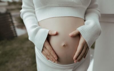 Une femme enceinte caresse doucement son ventre nu